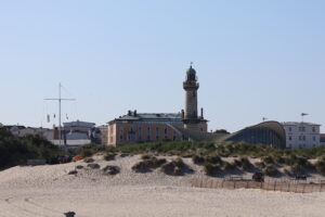 Blick über den Strand auf den Leuchtturm von Warnemünde