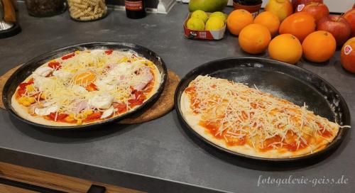 2-leckere-Pizza-kurz-vor-dem-backen-im-Holzofen