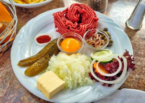 Tatar<br> ist ein Hackfleischgericht vom Rind, das aus rohem hochwertigem, sehnenfreiem und fettarmem Muskelfleisch wie Oberschale, Unterschale oder Nuss hergestellt wird und feiner zerkleinert ist als einfaches Rinderhackfleisch.         